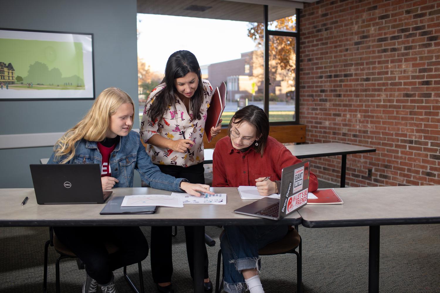 Criminology and criminal justice students and professor looking at evidence
