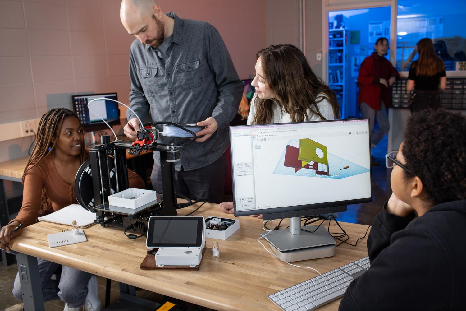 Digital Media (digital and studio arts) program, students and professor using 3-d printer