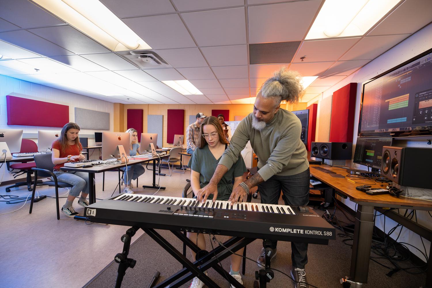 Jeff Bailey, professor of Music Production, helping student with keyboard