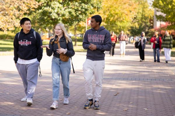 Three students walking on Hamline campus